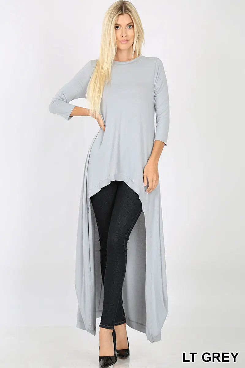 Light grey women's high low tunic dress with long sleeves styled with black pants and heels